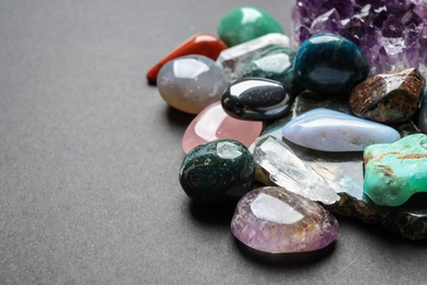 Different gemstones on dark table, space for text