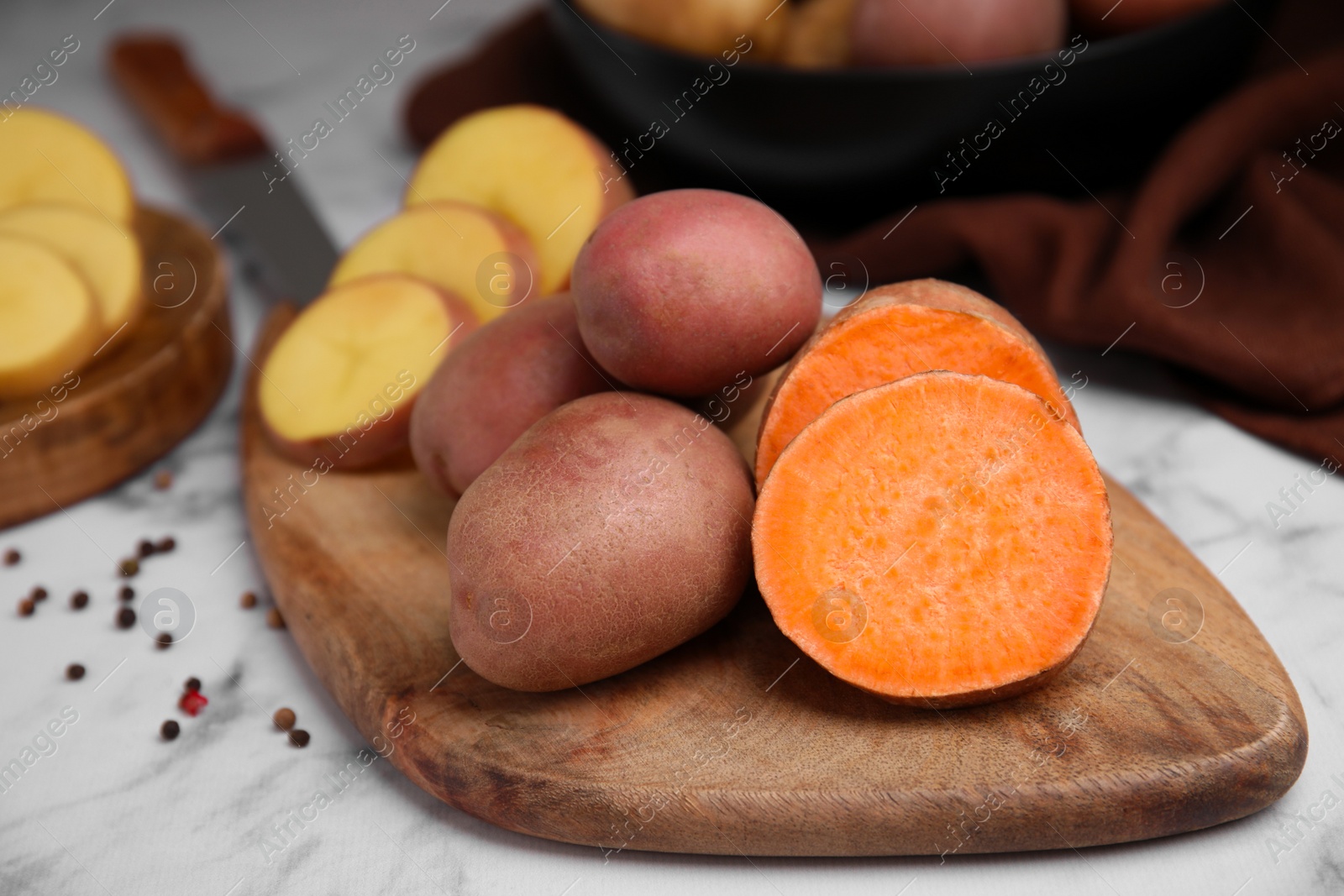 Photo of Different types of fresh potatoes on wooden board