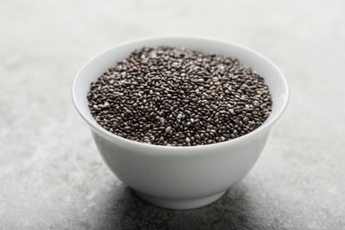 Photo of Bowl with chia seeds on grey table