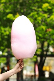 Photo of Woman holding sweet cotton candy in park, closeup