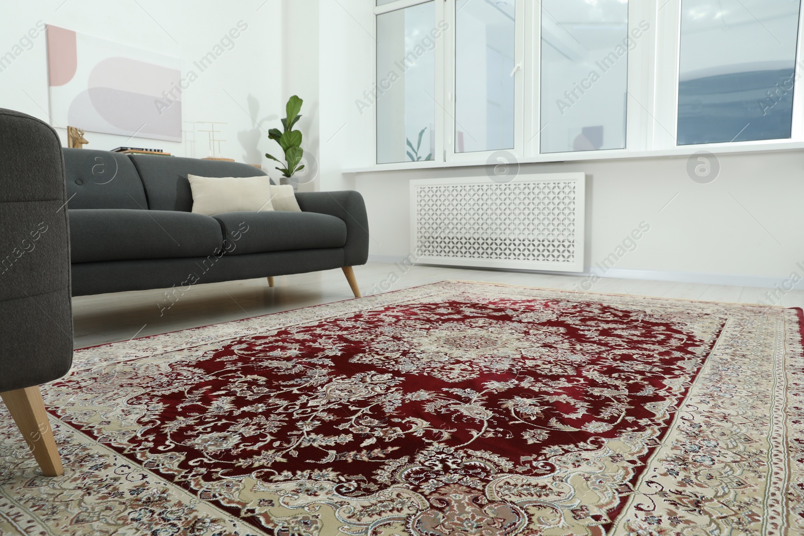 Photo of Cozy room interior with stylish furniture and soft carpet with beautiful pattern