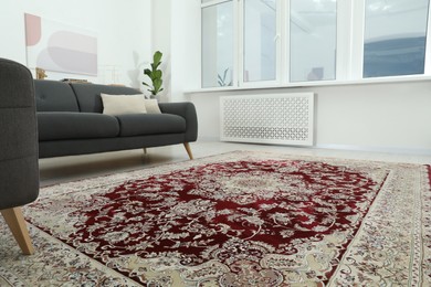 Photo of Cozy room interior with stylish furniture and soft carpet with beautiful pattern