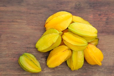 Photo of Delicious ripe carambolas on wooden table, flat lay