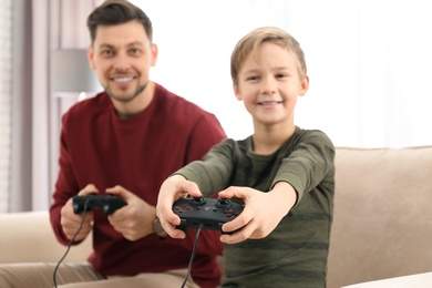 Photo of Father and son playing video games at home