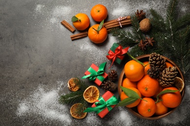 Photo of Flat lay Christmas composition with fresh tangerines and gifts on grey background, flat lay. Space for text