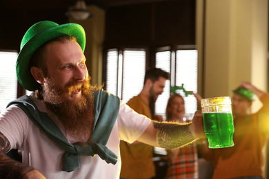 Photo of Man with glass of green beer in pub. St. Patrick's Day celebration