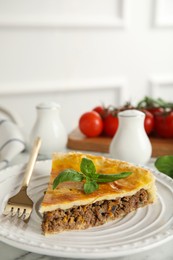 Photo of Piece of delicious pie with minced meat on table indoors