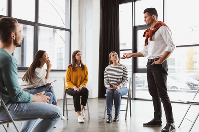 Photo of Psychotherapist working with patients in group therapy session indoors