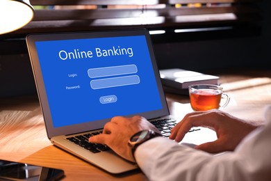 Man using online banking application on laptop at table, closeup
