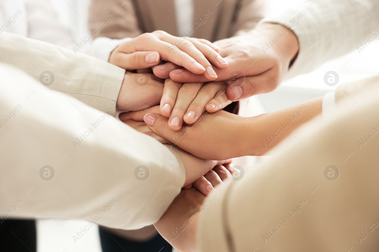 Photo of Group of people holding hands together indoors, closeup. Unity concept