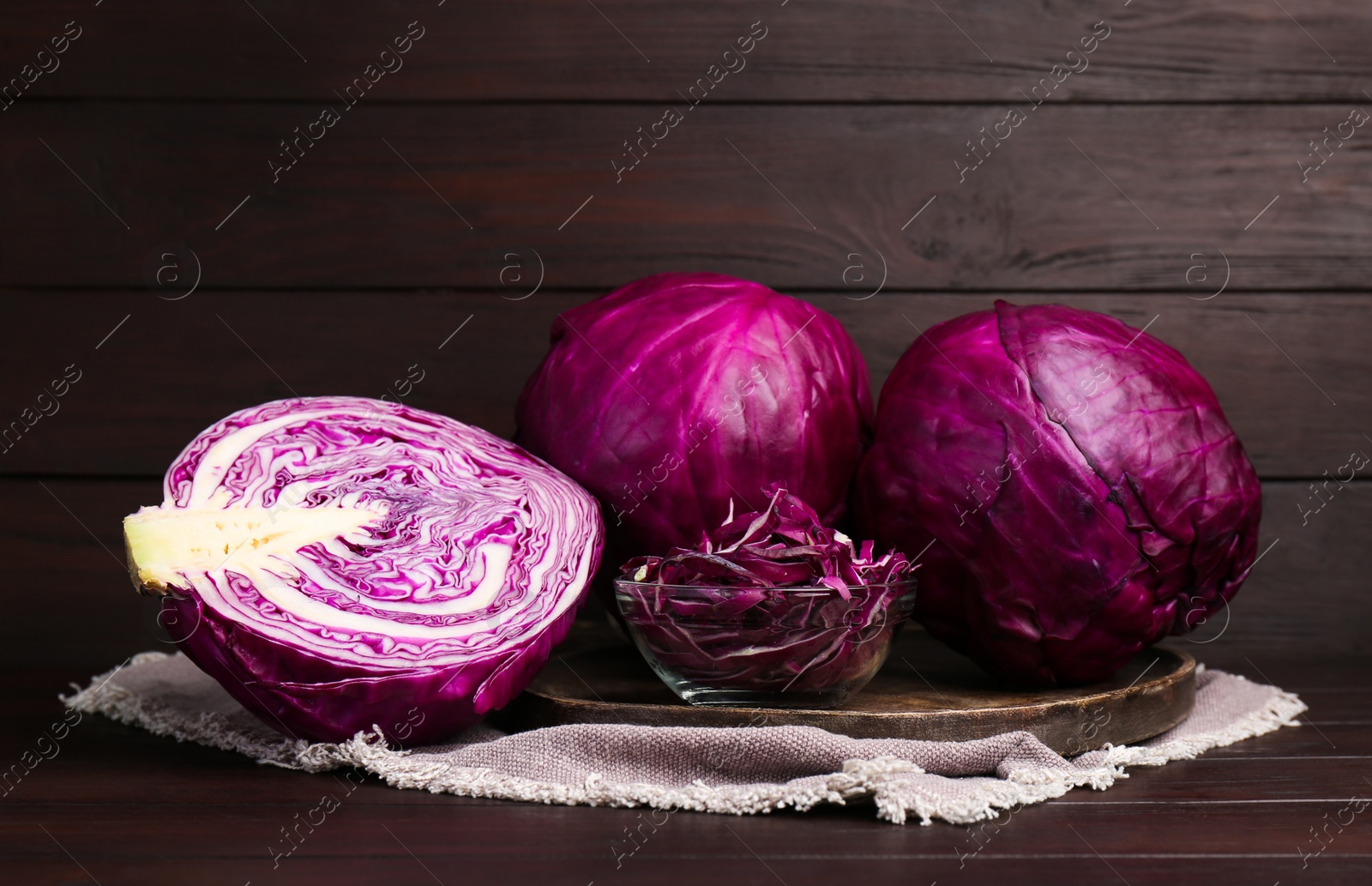 Photo of Whole and cut ripe red cabbages on wooden table