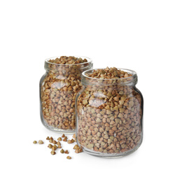 Photo of Organic green buckwheat in glass jars isolated on white