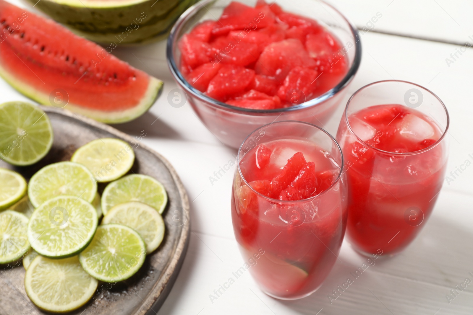 Photo of Fresh watermelon drink with lime and ingredients on white wooden table