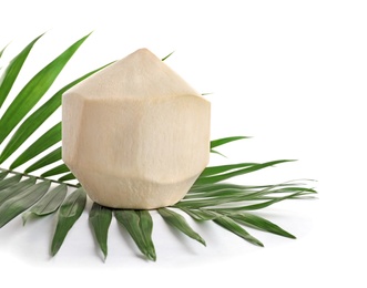 Photo of Fresh peeled coconut and palm leaf on white background