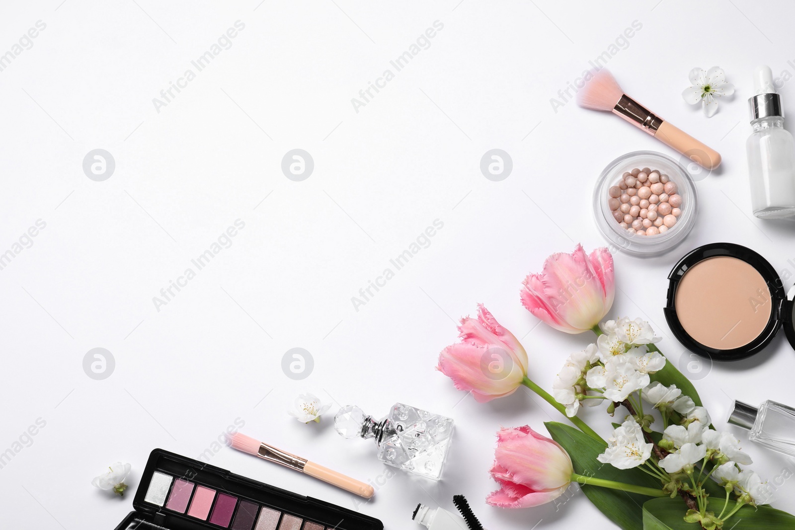 Photo of Flat lay composition with different makeup products and beautiful spring flowers on white background, space for text