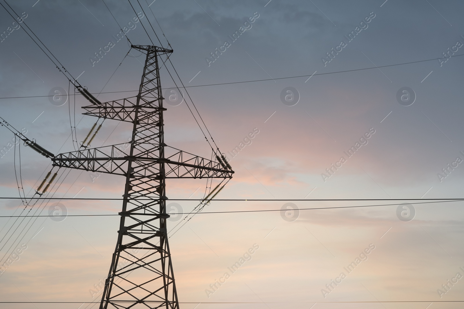 Photo of High voltage tower at sunset, low angle view