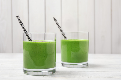 Tasty kale smoothie on white wooden table