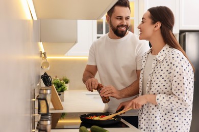 Photo of Happy lovely couple cooking together in kitchen
