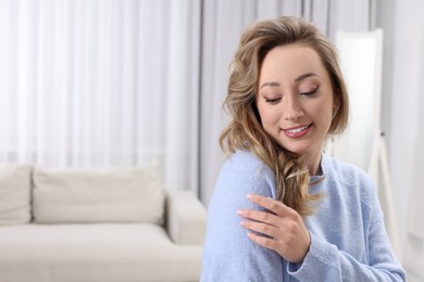 Portrait of smiling woman with curly hair at home. Space for text