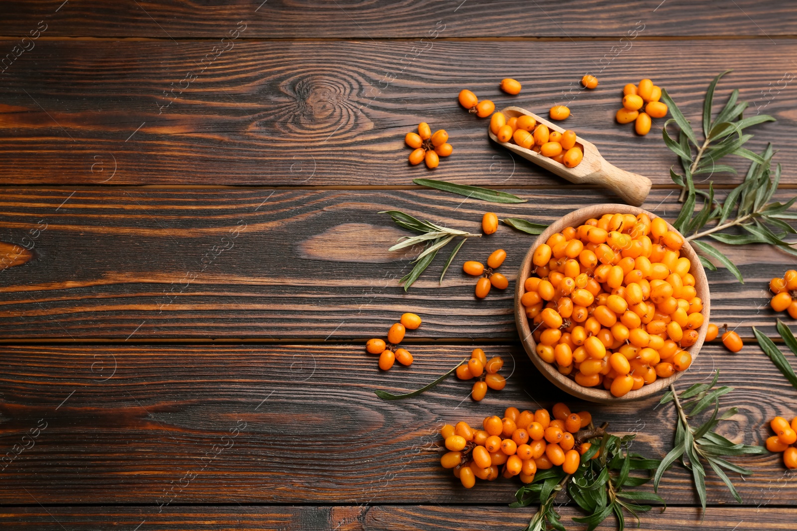 Photo of Fresh ripe sea buckthorn on wooden table, flat lay. Space for text