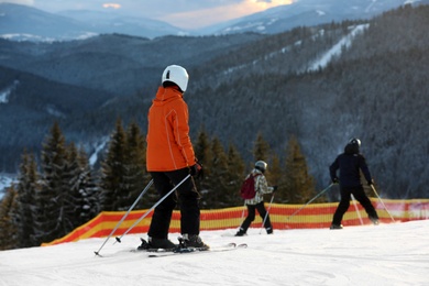 Photo of People skiing on snowy hill in mountains. Winter vacation