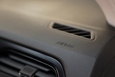 Photo of Safety airbag sign and air vent inside car, closeup