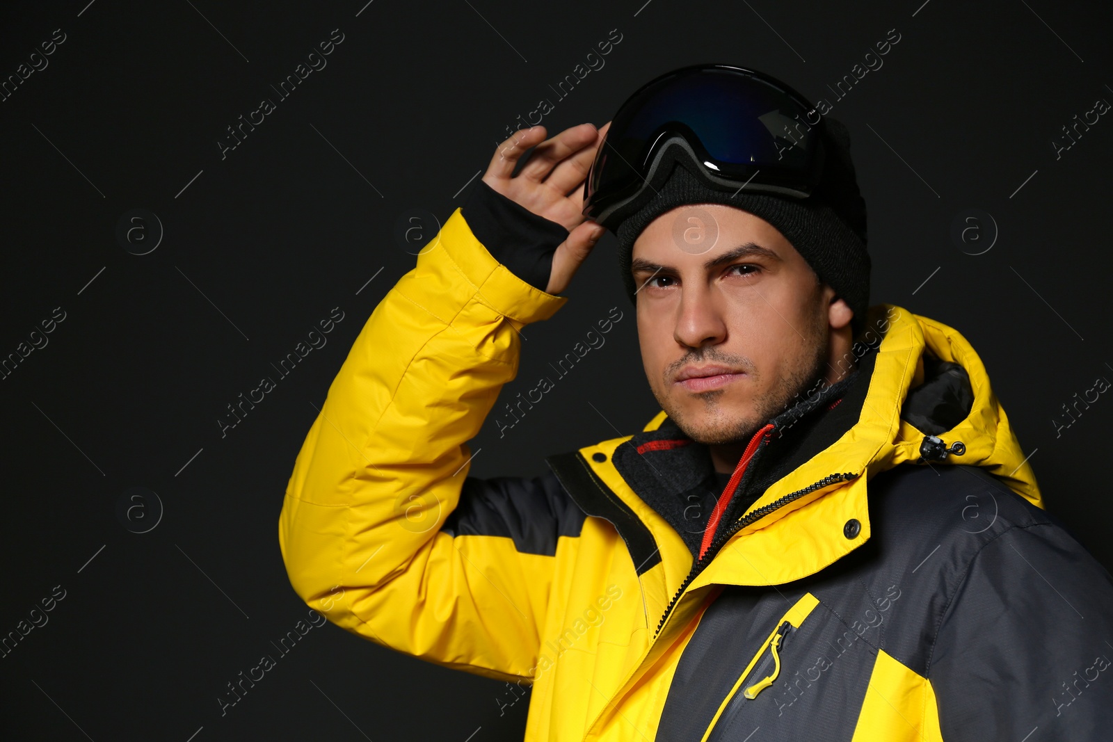 Photo of Man wearing stylish winter sport clothes on black background