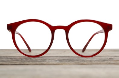 Photo of Stylish glasses with brown frame on wooden table against white background