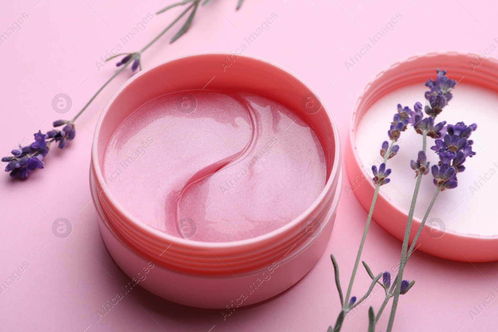Photo of Package of under eye patches and lavender flowers on pink background. Cosmetic product