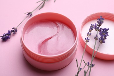 Photo of Package of under eye patches and lavender flowers on pink background. Cosmetic product