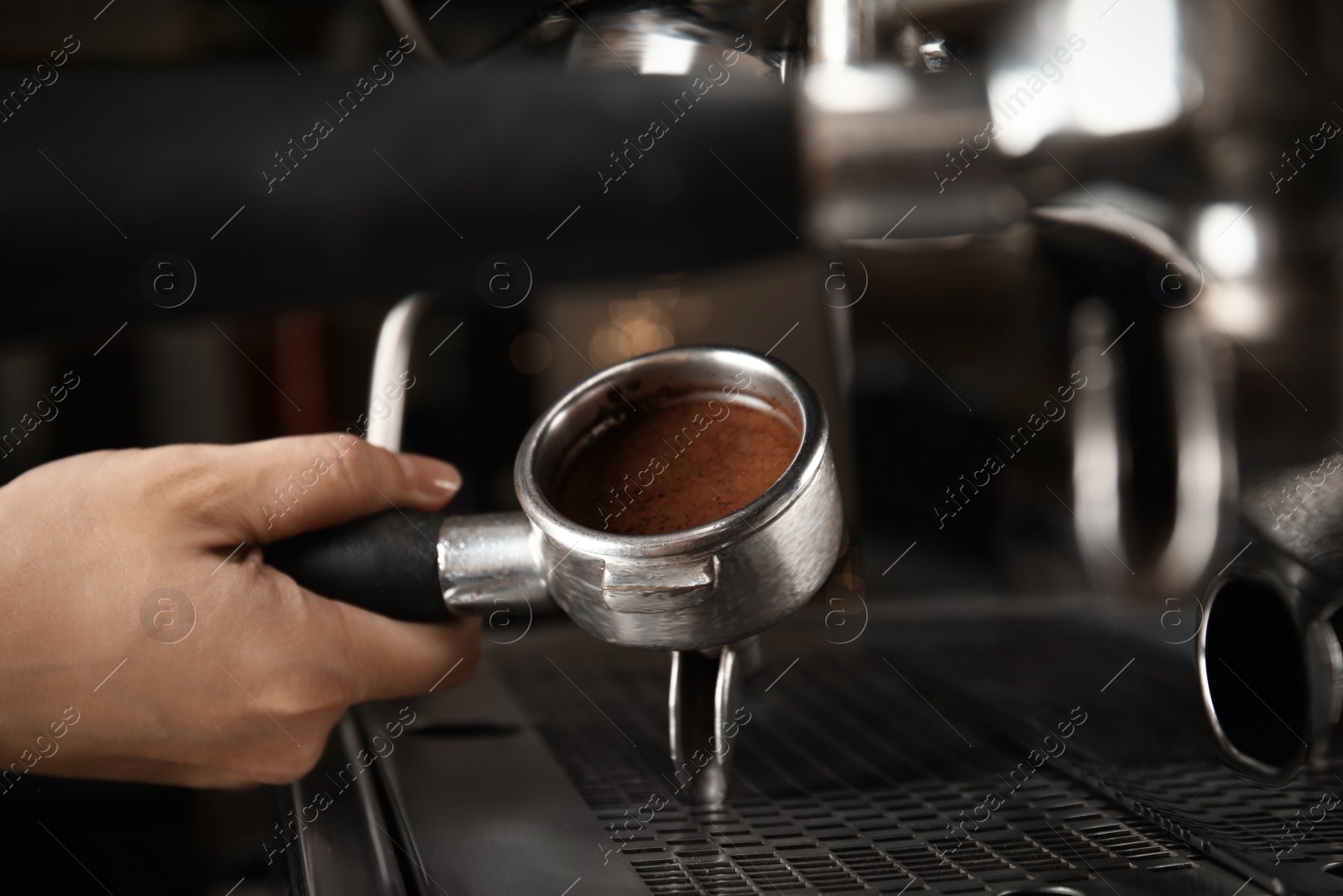 Photo of Barista making espresso using professional coffee machine, closeup