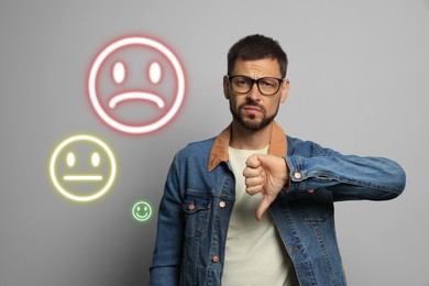 Image of Complaint. Dissatisfied man showing thumbs-down on grey background. Illustrations of sad, neutral and happy faces near him