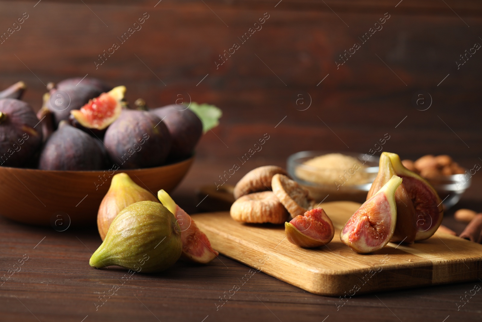 Photo of Tasty raw figs on brown wooden table