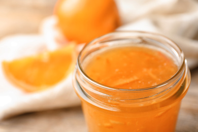 Photo of Homemade delicious orange jam on table, closeup view