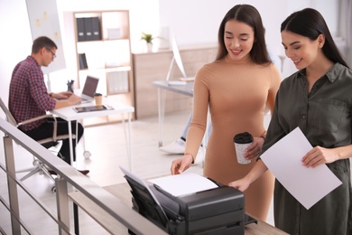 Photo of Employees using new modern printer in office