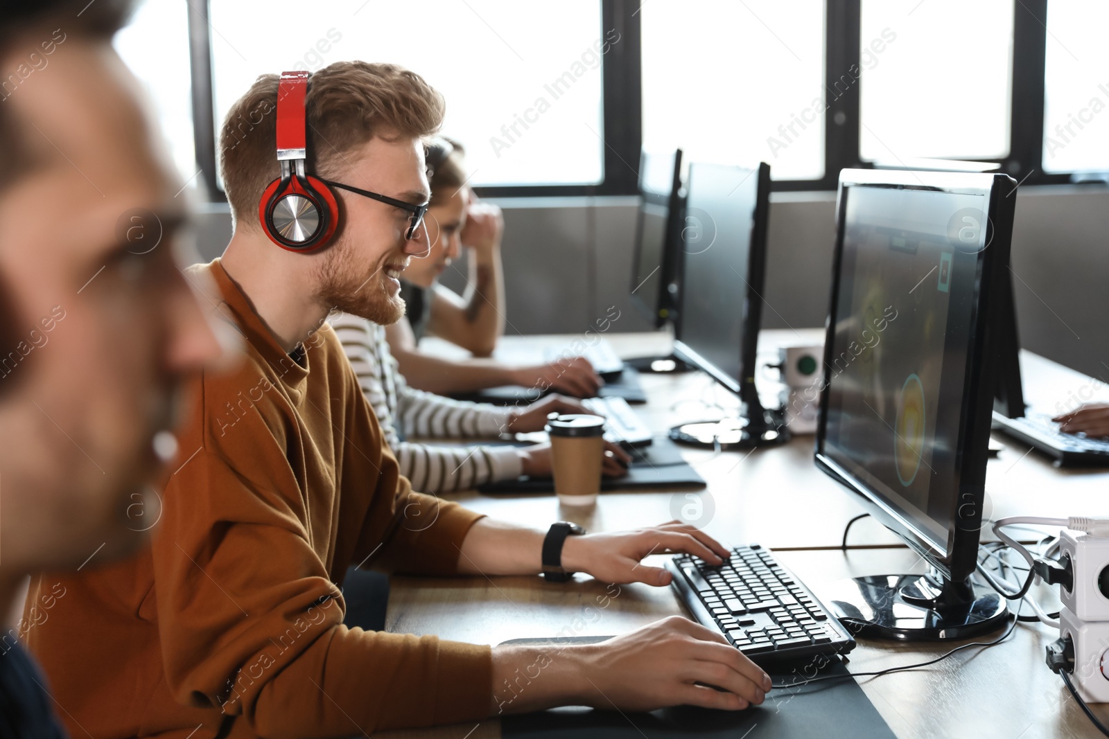 Photo of Man playing video game in internet cafe