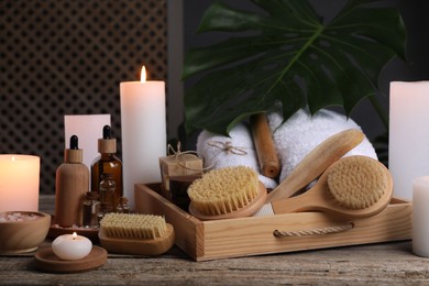 Photo of Composition with different spa products and burning candles on wooden table