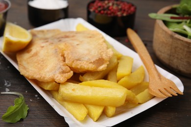 Delicious fish and chips served on wooden table, closeup