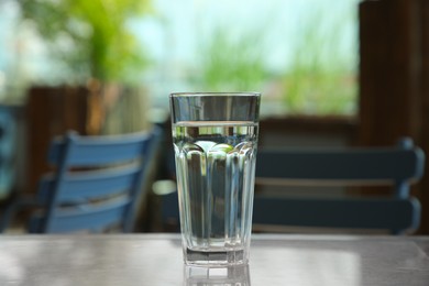 Glass of fresh water on table indoors