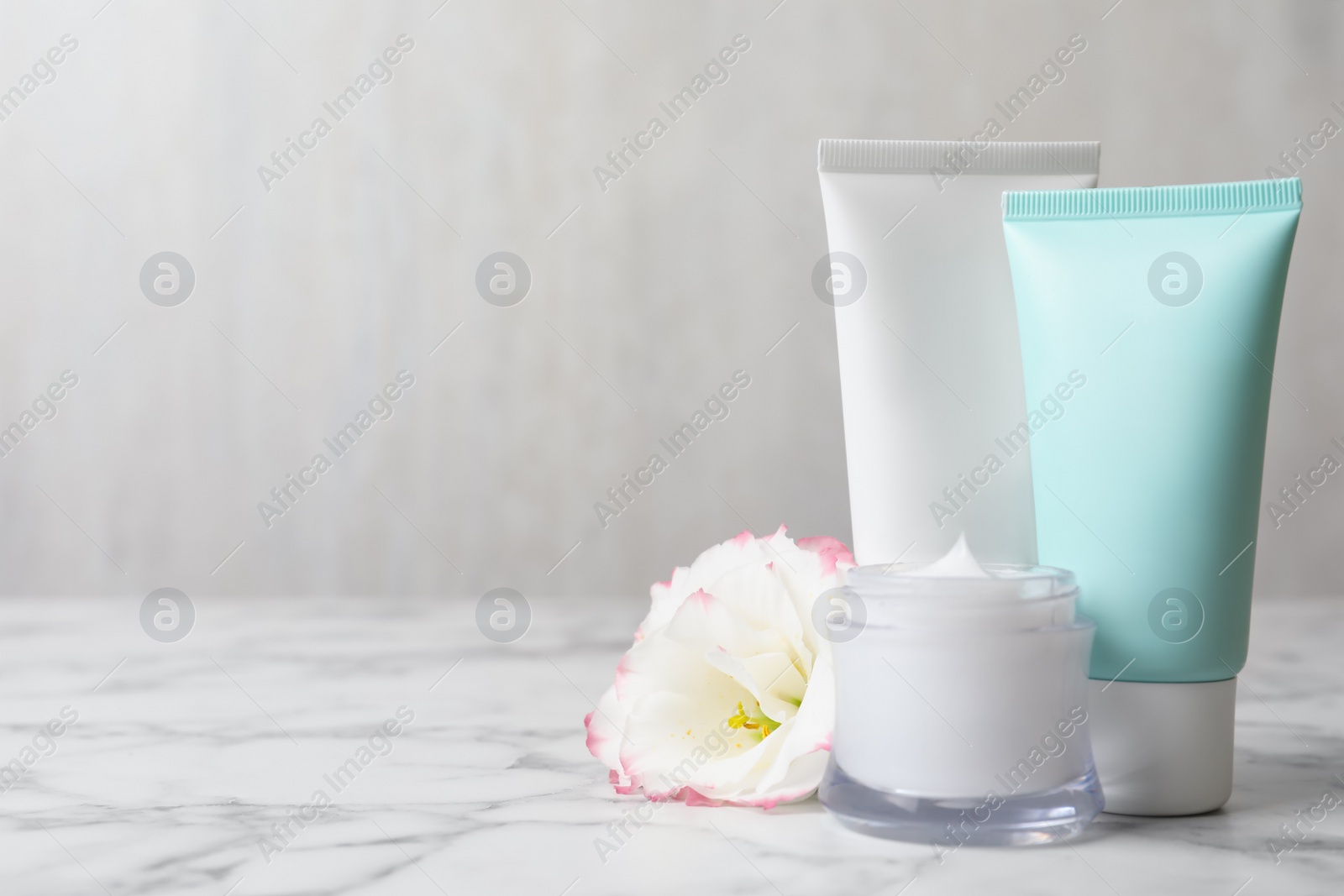 Photo of Composition with cosmetic products on white marble table. Space for text
