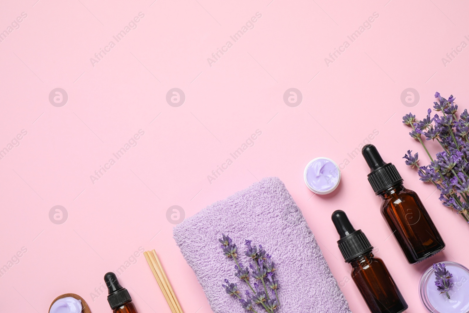 Photo of Cosmetic products and lavender flowers on pink background, flat lay. Space for text