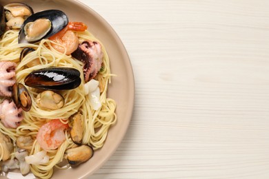 Delicious pasta with sea food on white wooden table, top view. Space for text