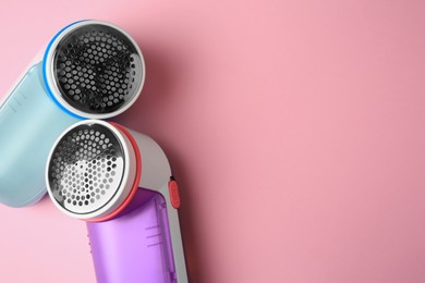 Modern fabric shavers on pink background, flat lay. Space for text