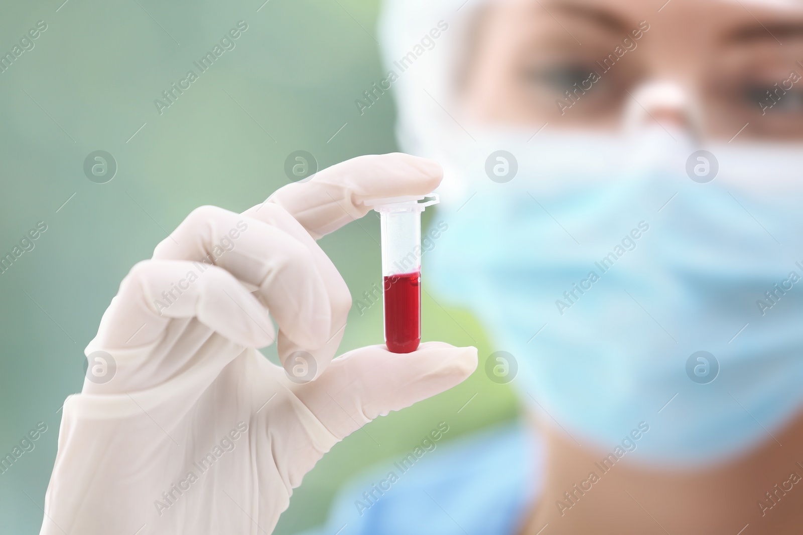 Photo of Scientist holding test tube with blood sample in laboratory