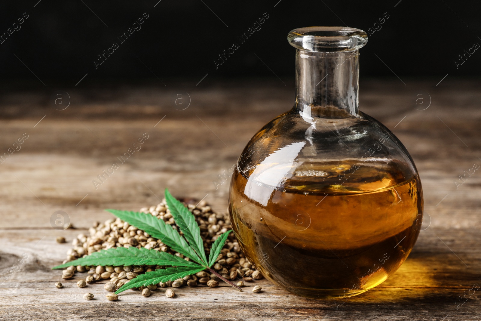 Photo of Composition with hemp oil on wooden table