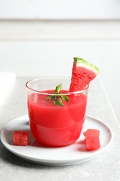 Summer watermelon drink with mint in glass served on table