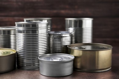 Photo of Many closed tin cans on brown table
