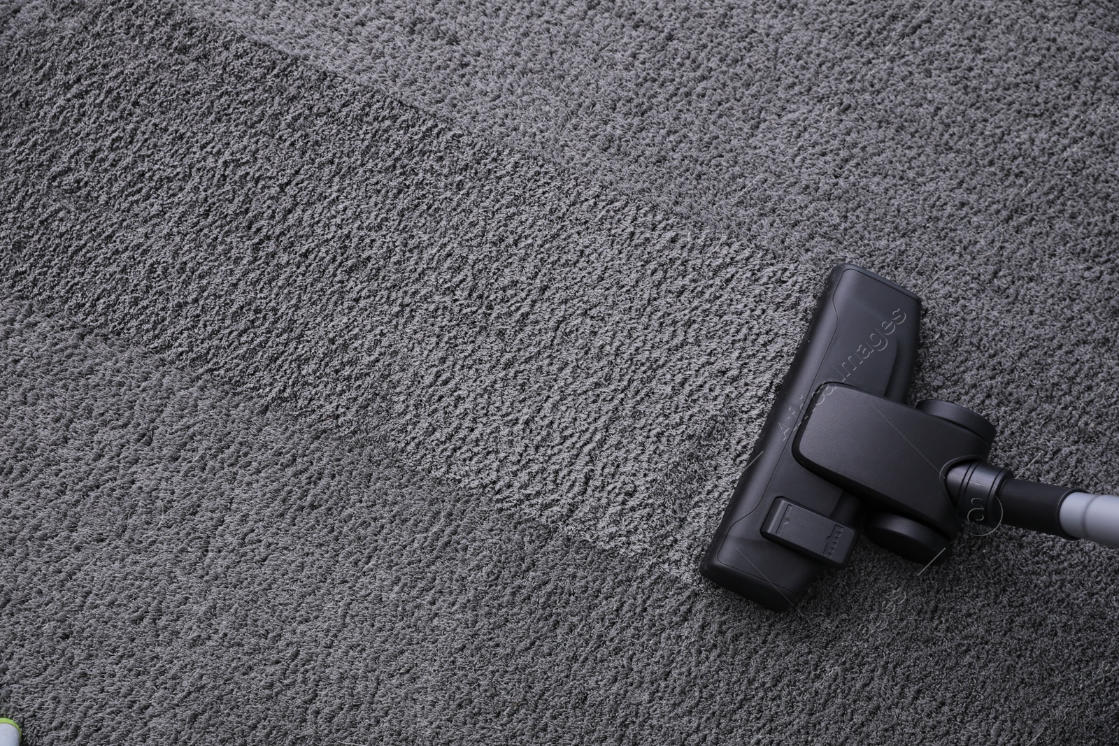 Photo of Modern vacuum cleaner on carpet, top view. Space for text