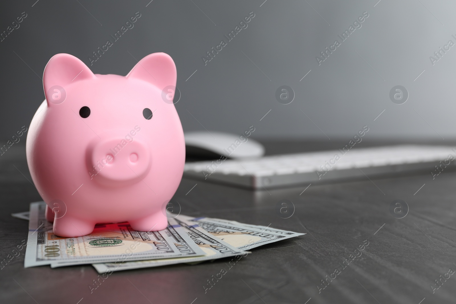 Photo of Pink piggy bank and banknotes on black table, space for text