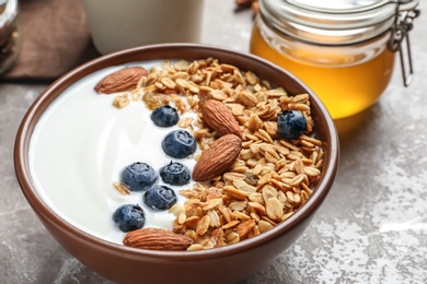 Photo of Tasty breakfast with yogurt, berries and granola on table